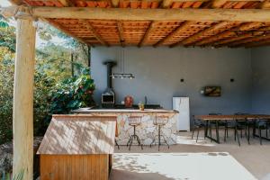 eine Außenküche mit einer Bar und einem Tisch in der Unterkunft Luxo e Aconchego na Natureza - DM in Domingos Martins