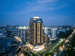 ShundeBodun International Apartment Foshan Shunde Fengjian Water Village Branch的夜晚城市中的高楼