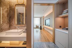 ShundeBodun International Apartment Foshan Shunde Fengjian Water Village Branch的带水槽和镜子的浴室