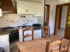 a kitchen with white cabinets and a table and a sink at Le Gîte d'Orion in La Bresse +17 photos