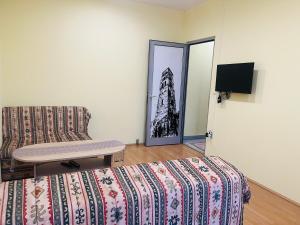 a room with a bed and a couch and a tv at Apartman Vinkov's center in Jajce