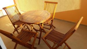 3 sillas, mesa de madera, mesa y sillas en Apartmani Maric, en Tivat