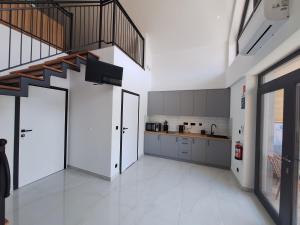 a large kitchen with white floors and a staircase at Ośrodek Szkoleniowo-Wypoczynkowy Akademii Bialskiej in Międzyrzec Podlaski