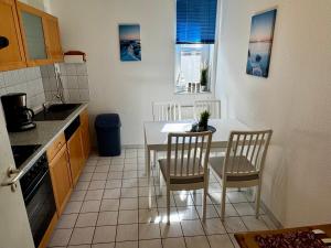 a kitchen with a table and chairs in a kitchen at Ferienwohnung am Yachthafen Waren Müritz in Waren