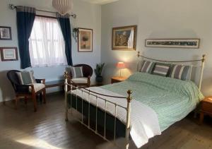 a bedroom with a bed and a chair and a window at Olive Tree House in Anoyira