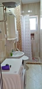 Un baño con lavabo, inodoro y ducha. en Apartmani Maric, en Tivat