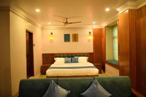 a bedroom with a bed and a green couch at Hotel Manal Suites in Green Island