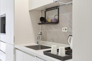 a kitchen with a sink and a counter top at 부산호텔그라체 Busan Hotel Grazie in Busan +74 photos