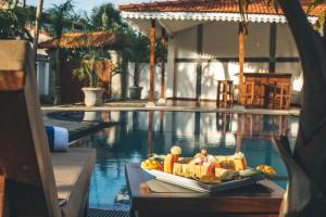 a bowl of fruit sitting on a table next to a swimming pool at Sisikirana Villa (Luxury Villa in Galle) in Unawatuna