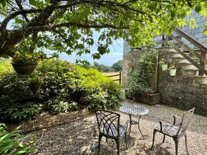 two chairs and a table in a garden at The Hayloft in Lostwithiel