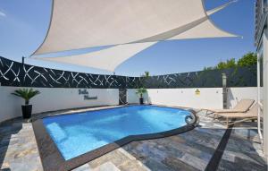 ein Swimmingpool mit einem Stuhl und einem Sonnenschirm in der Unterkunft 2 Bedroom Amazing Home In Bjelovar in Bjelovar