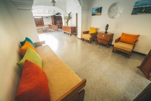 a living room with a couch with colorful pillows at Sisikirana Villa (Luxury Villa in Galle) in Unawatuna