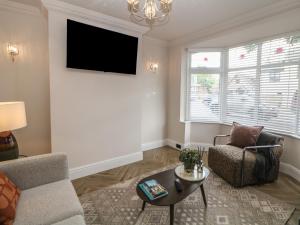 a living room with a couch and a tv on a wall at 37 Berry Hill Lane in Mansfield