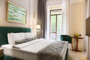 um quarto de hotel com uma cama grande e uma janela em Maestro Address Baku Hotel em Baku