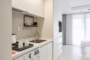 a white kitchen with a sink and a bed at 부산호텔그라체 Busan Hotel Grazie in Busan