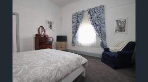 a bedroom with a bed and a chair and a window at LMN Cottage in Spalding