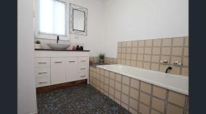 a bathroom with a large tub and a sink at LMN Cottage in Spalding