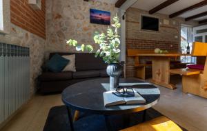 a living room with a table with a vase of flowers at Country house Maslina by Villas Guide in Metković