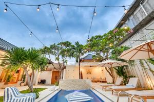a patio with a pool and chairs and trees at Villa Mawali in Legian