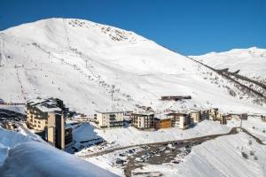 a snow covered mountain with a city and a town at 4 personnes au pied des piste et sentier de randonné in Saint-Lary-Soulan