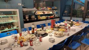 a long table with food on it with blue chairs at The Honey House Sóc Sơn in Sóc Sơn