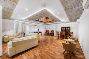 a living room with white furniture and a ping pong table at Kyomi Service Apartments in Gurgaon