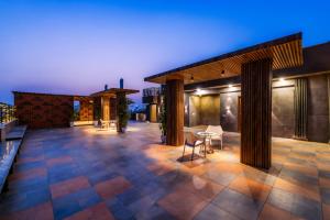 an outdoor patio with a table and chairs at night at Kyomi Service Apartments in Gurgaon