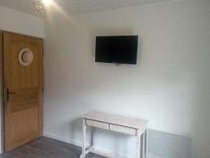 a room with a table and a tv on a wall at Ô 17 i aime in Le Tampon