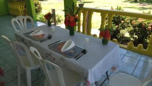 a white table with plates and napkins on a balcony at VureVure Homestay in Mbouma