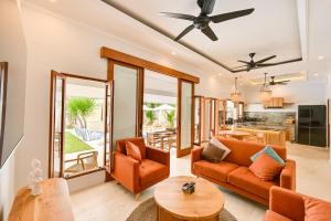 a living room with orange furniture and a table at Villa Mawali in Legian