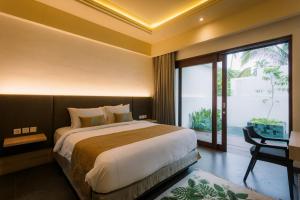 a bedroom with a large bed and a large window at Daun Lebar Villas in Payangan