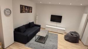 カイザースラウテルンにあるCity Central Helenenstrのリビングルーム(黒いソファ、テレビ付)