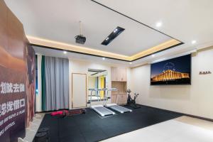 een kamer met een gymzaal met twee stoelen en een muur bij Vyluk Hotel Suzhou Xiangcheng Avenue & Global Harbor in Suzhou