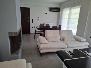 a living room with a white couch and a table at Maisonette in Marousi in Athens