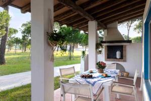 a table and chairs on a porch with a fireplace at Villaggio San Paolo in Cavallino-Treporti