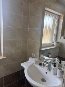 a bathroom with a white sink and a mirror at Appartementshaus Vlora 2 App 4 in Bad Füssing +1 photo