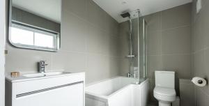 y baño con lavabo, aseo y bañera. en VITAMYN SEA, 4 bed house, Sleeps 8, Sea views, 5 min walk to harbour and beaches, en St Ives 20 fotos más