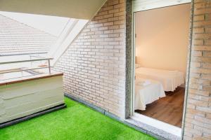 a room with a brick wall and green grass at Apartamentos Suaces in Noja +97 photos