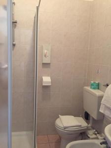 ein Bad mit einer Dusche, einem WC und einem Waschbecken in der Unterkunft Pensione Giardino in Lignano Sabbiadoro