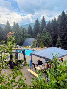 a tent is set up next to a swimming pool at Pine Hill Poiana Marului in Poiana Mărului