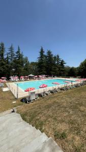 a large swimming pool with chairs and umbrellas at Residenze del Borgo in Zavattarello