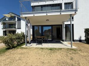 a house with a table and chairs on a patio at Suite Happiness in Uhldingen-Mühlhofen