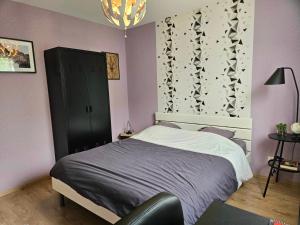 a bedroom with a bed and a black cabinet at Maison très bien équipée avec piscine et au calme in Bourg-en-Bresse +20 photos
