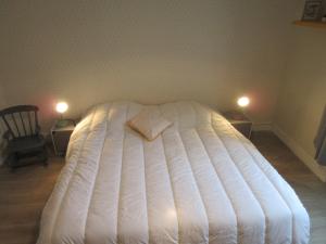 a large white bed in a bedroom with two lights at Brav ehanou Morgat in Crozon
