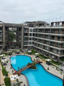 Un gran edificio de apartamentos con una gran piscina. en The Diamond In City Luxury Suites By ZENORA Living, en Accra