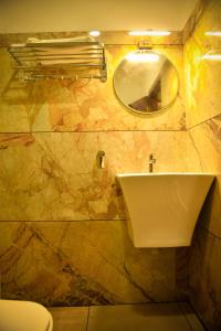 a bathroom with a sink and a mirror at Hotel Manal Suites in Green Island