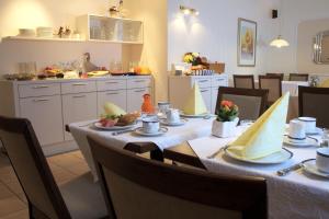 a dining room with a table with food on it at Hotel-Pension Pöhling in Lippstadt