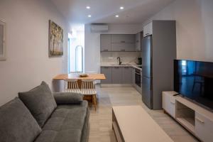 un salon avec un canapé et une cuisine dans l'établissement The Cozy Twins, à La Canée
