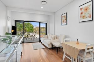 a living room with a table and a couch at Harbour Glimpses & Modern Comfort in Sydney