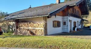 a house with a pile of fire wood on the side at Ferienwohnung Theresia Oberm, Kreuth-Enterbach in Kreuth